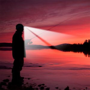 Fisherman wearing Powercap 25/10 microfiber LED lighted visor next to lake in low lighting