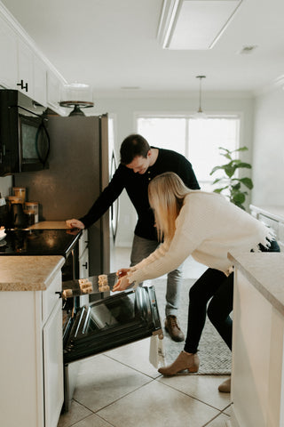 Couple getting cookies out of oven