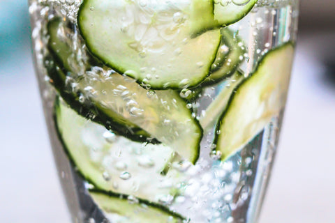 cucumber slices wrapped around inside of cocktail glass