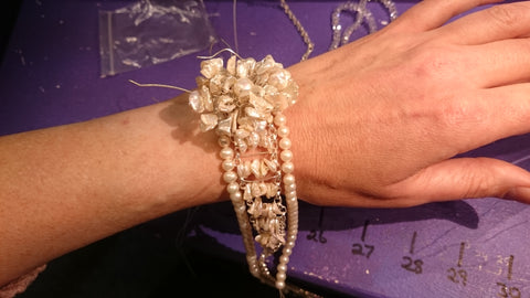 Le bracelet de mariée sur mesure est complété par une fleur assortie à son couvre-chef.
