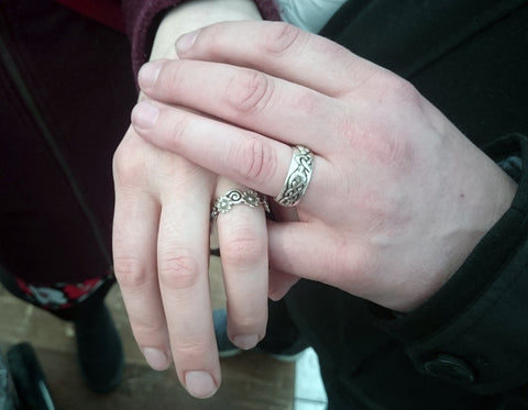Pareja feliz con sus anillos de compromiso, hechos a mano y diseñados por Elena Brennan Jewellery en Cavan, Irlanda.