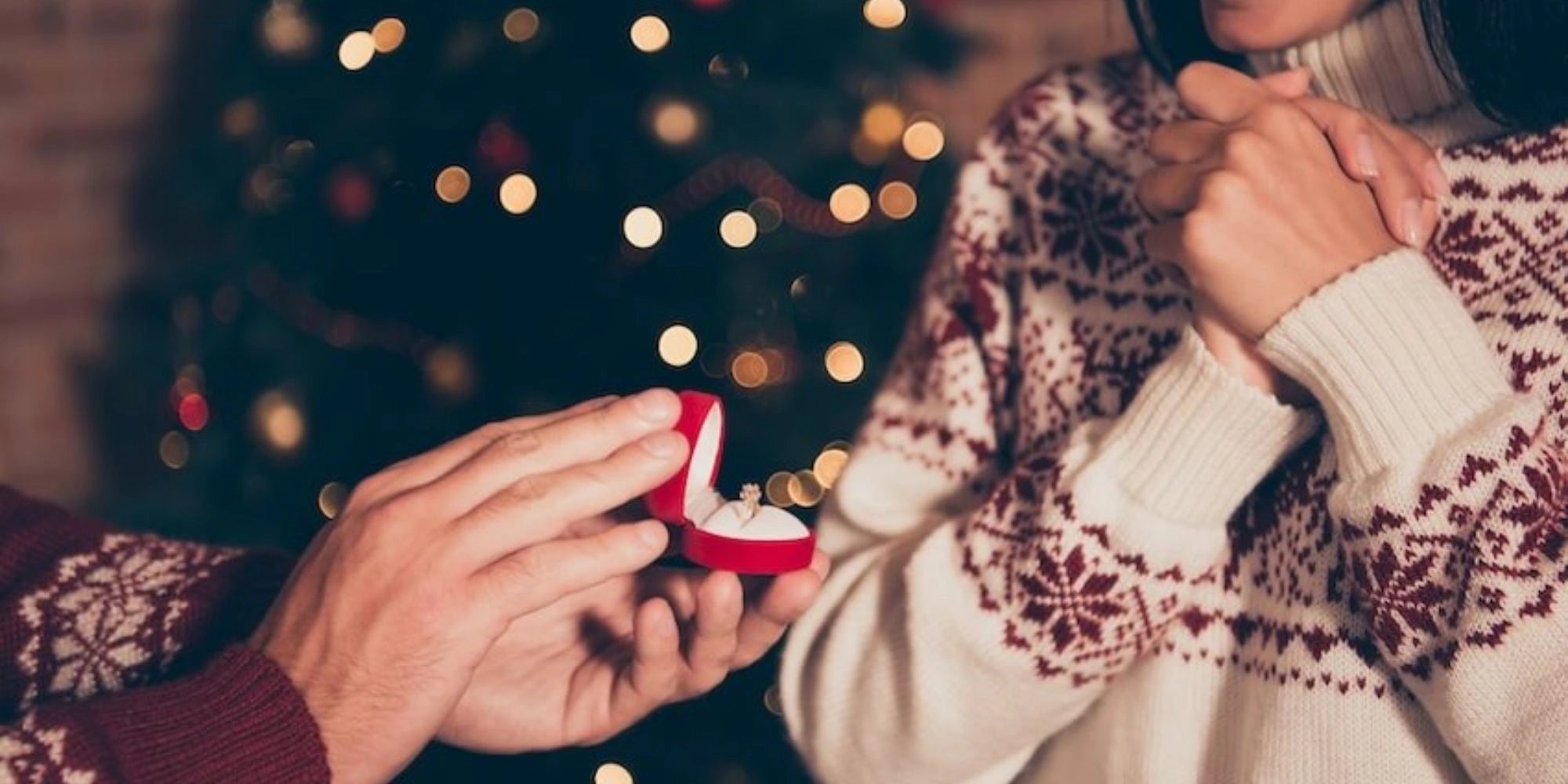 Christmas proposal with diamond engagement ring in red ring box, romantic holiday engagement idea for couples.