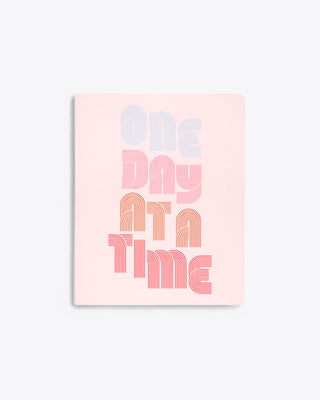 daily planner cover in blush pink with "ONE DAY AT A TIME" text graphic