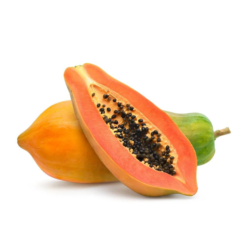 A whole and a halved papaya with black seeds on a white background.