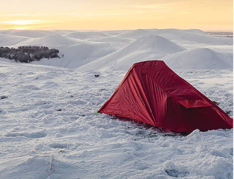 Red tent pitched in snowfield
