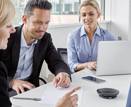 Group of people taking call on speakerphone