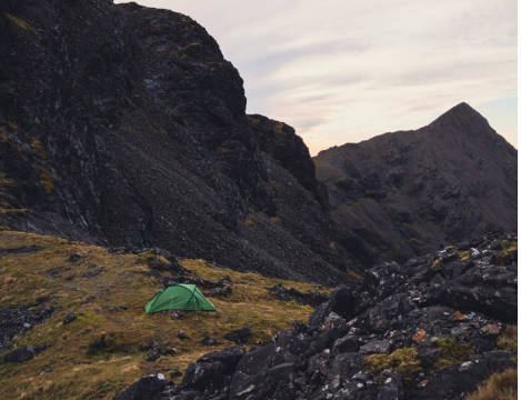 Green Vango tent in front of rock face