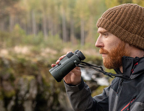 Bearded man using Hawke binoculars