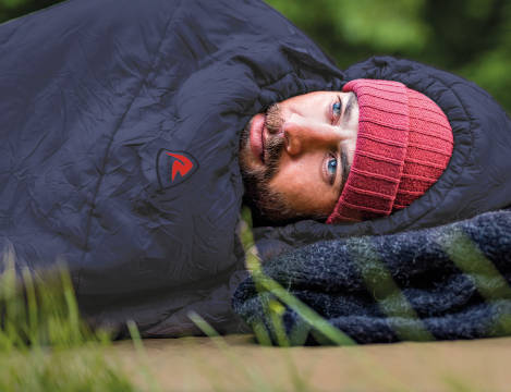 Man lying on ground in sleeping bag