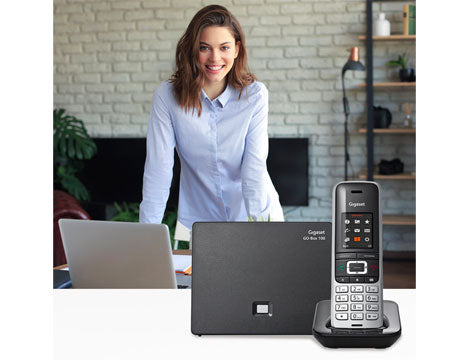 Woman standing next to Gigaset landline phone