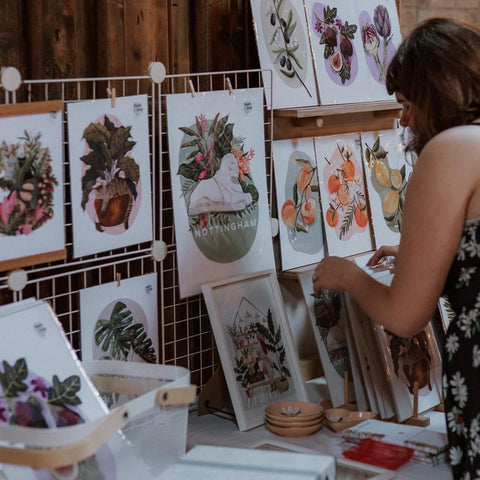 women hanging illustrations on board