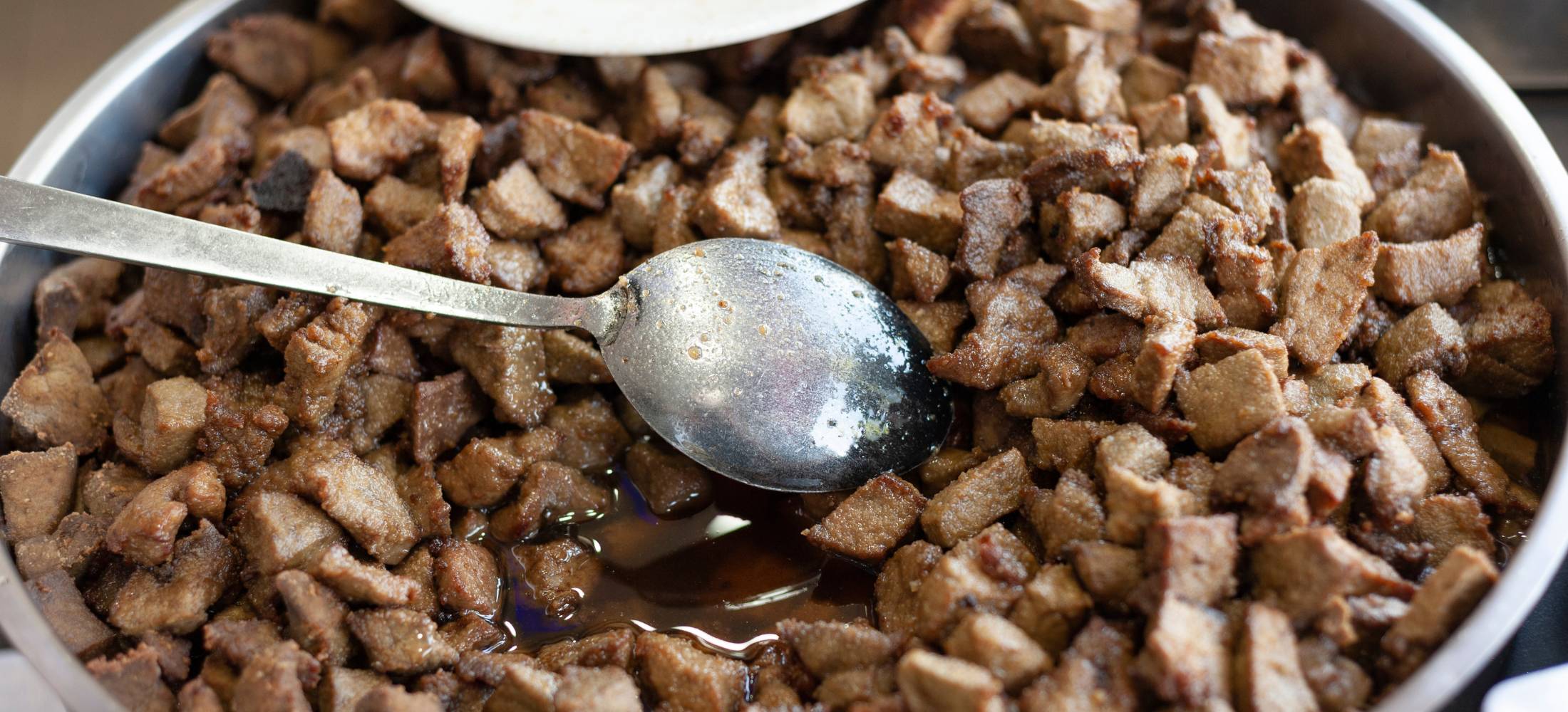 A bowl filled with cooked beef liver for dogs