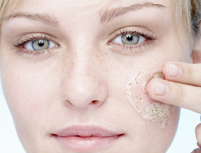 A women exfoliating her face