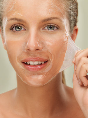 A woman taking a chemical peel off her face