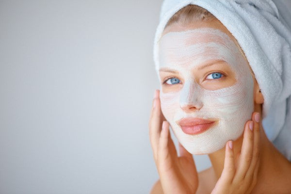 A girl with a mask on her face and a towel on her head