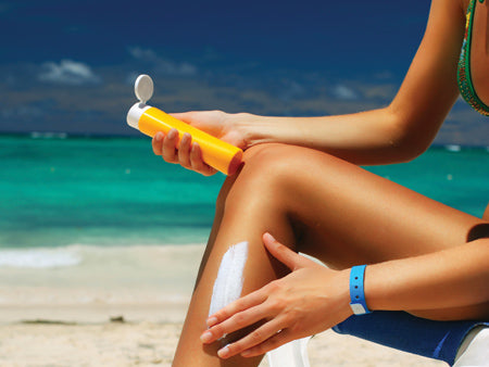 A girl applying sunscreen on her leg