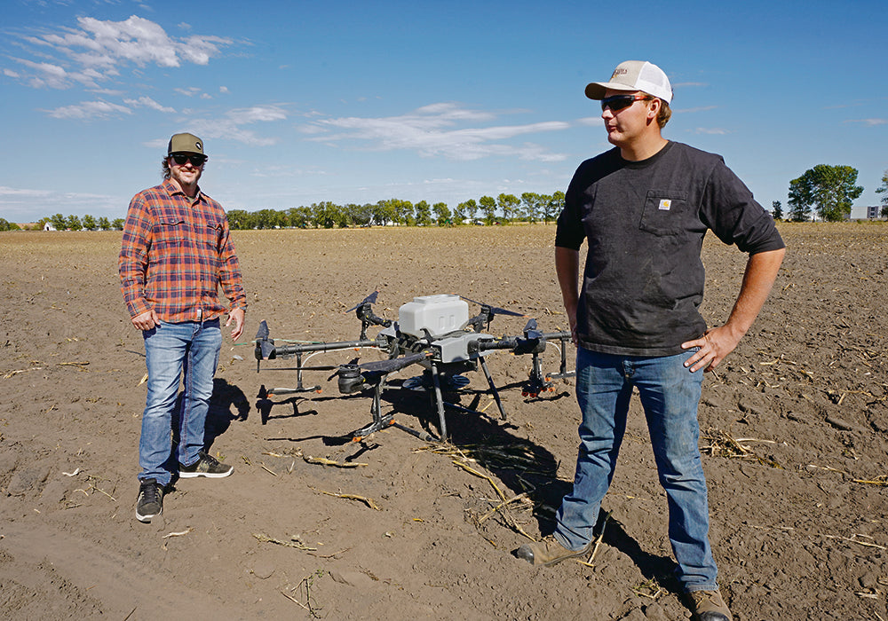 Maverick chief executive officer Adam Shaw, left, and pumpkin farmer Bear Bouwman discuss Bouwman’s move to the larger T40 application drone.
