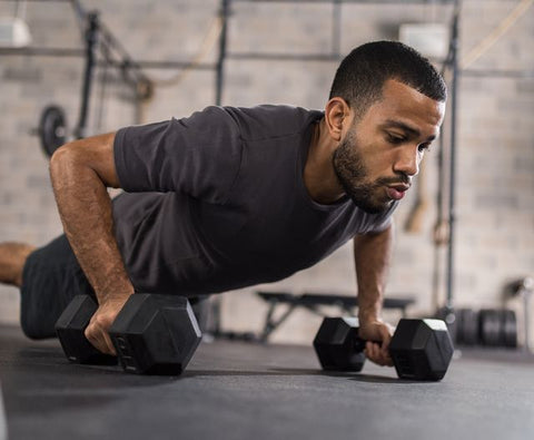 man doing pushups with hex dumbbells