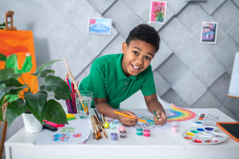 boy-standing-table-drawing-looking-camera-montessori-play