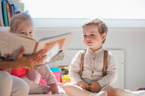 children-reading-book-together-with-another-person