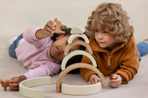Girl and boy playing with wooden balance montessori toy