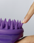 A model tucks a purple denticle of the Dr. Groot Premium Scalp Cleansing Brush