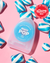 A container of Reach POP Mint Dental Floss lying on a pink table with mint candies scattered around