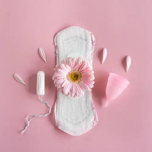 Serviette hygiénique avec un tampon, une coupe menstruelle  et une fleur