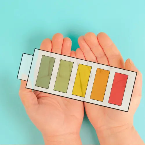 illustration de batterie avec différents stades de couleurs tenu dans les main d'une personne