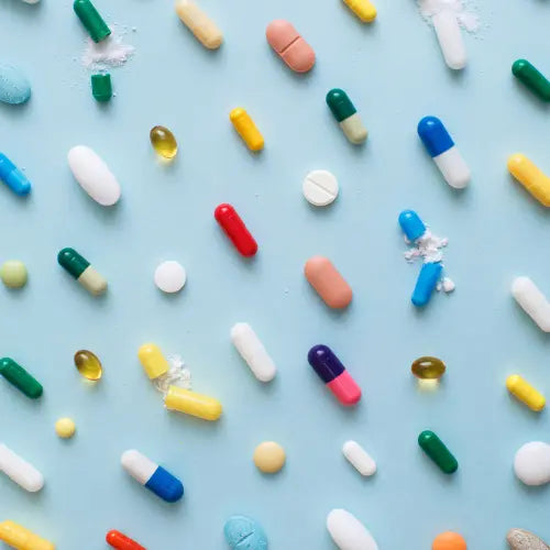 Various pills laid on a blue background