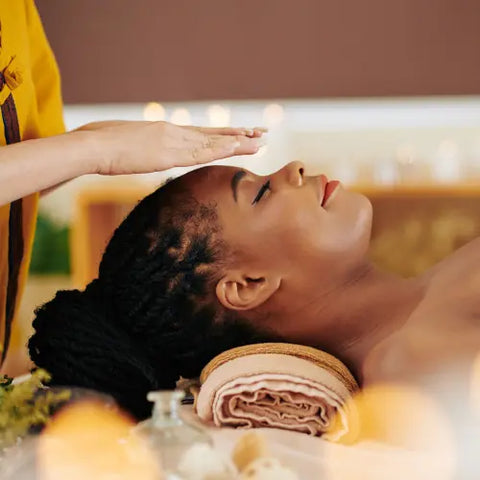 femme allongée comme pour un massage avec une autre femme qui à ses mains au dessus de sa tête et qui lui transmet des énergie