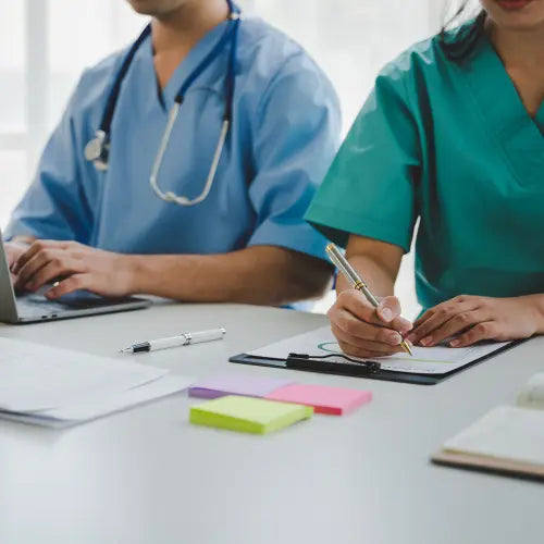 Two people in front of an office in medical clothing