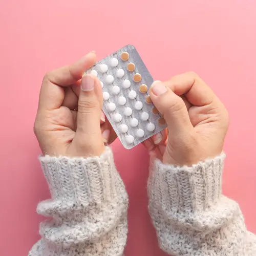 femme tenant dans ses mains un plaquette de pilules contraceptives