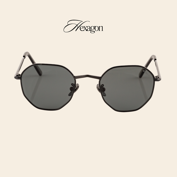 Memorí black hexagon frame sunglasses are pictured from the front. These sunglasses feature a small fit and gray lenses which are great for driving as they do not distort colors.