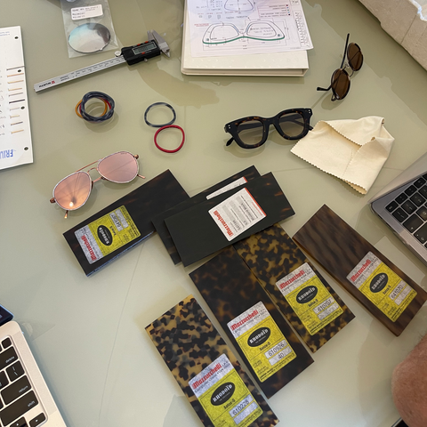 Image of tabletop of workspace that includes eyewear in the process of being designed