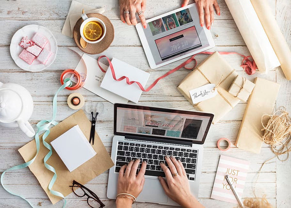 flatlay de uma mesa de trabalho com duas mulheres trabalhando em seus laptops com diversos itens decorativos para personalizar