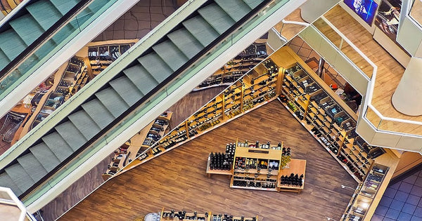 imagem de cima de um shopping center com destaque para uma loja de vinhos com um balcão no centro de marcas de vinhos específicas em exemplo de trade marketing