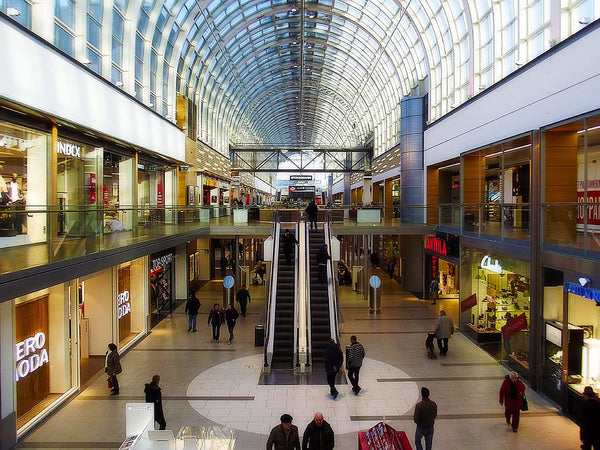 imagem de shopping center mostrando dois pisos repletos de lojas e clientes