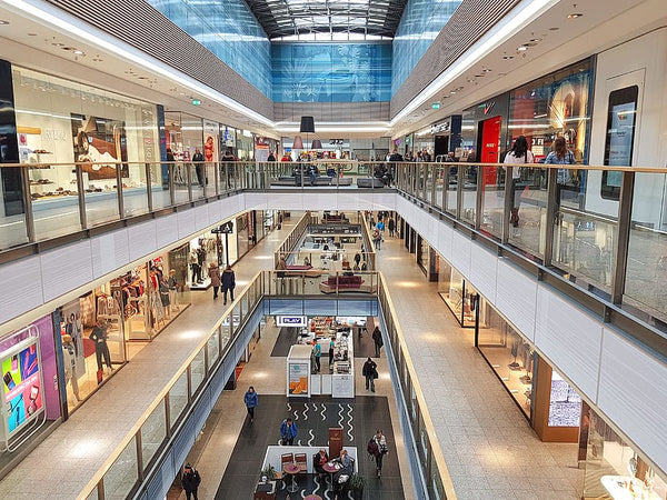imagem superior de um shopping center mostrando parte dos três pisos e suas lojas e quiosques