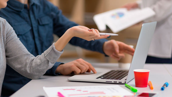 colegas de trabalho analisam gráficos e dados no laptop em reunião de trabalho sobre trade marketing