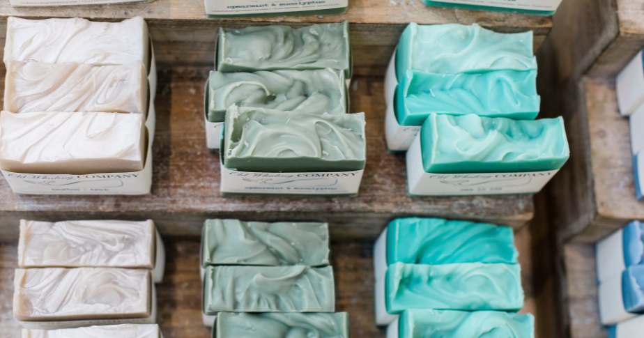 Sabonetes artesanais já prontos para venda, embalados e dispostos em pequenas fileiras.