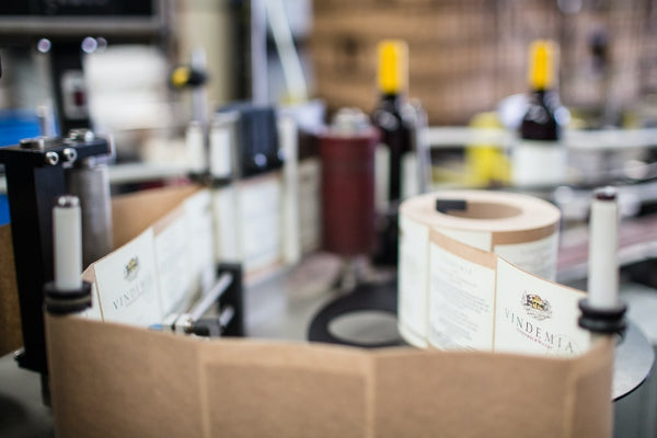 Vinhos sendo etiquetados, representando a logística de um clube de assinatura de vinhos