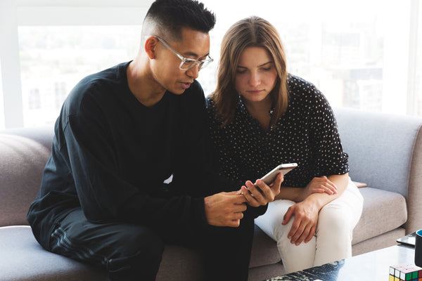 colegas de trabalho fazendo análise de concorrentes no smartphone