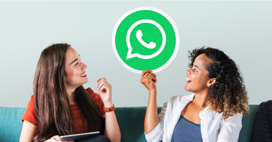 Duas mulheres sentadas em um sofá, segurando um ícone do WhatsApp