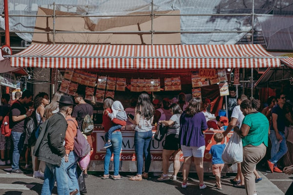 Foto para ilustrar artigo sobre tráfego pago mostra uma barraca de rua. À frente da barraca, há uma dezena de clientes aguardando serem atendidos.