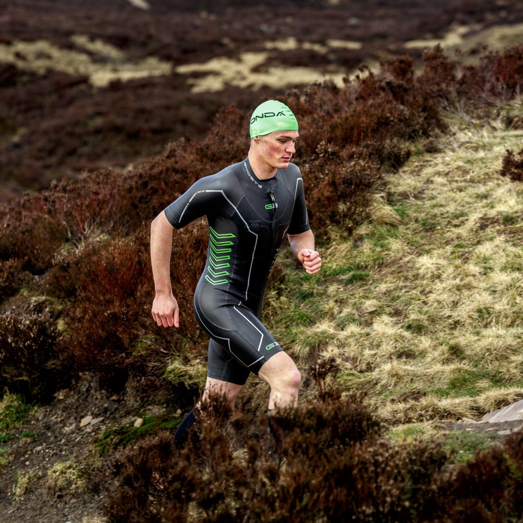 Athlete in wetsuit running in the Yorkshire Moore's
