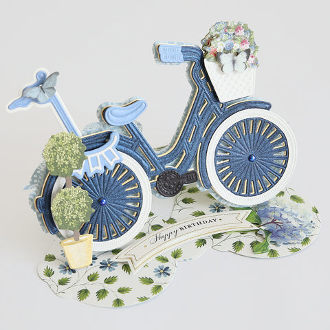 A pop up card with a blue bicycle and flowers.