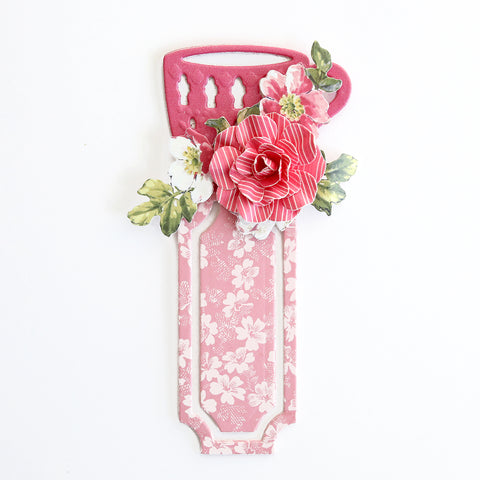 A pink bookmark with flowers on it.