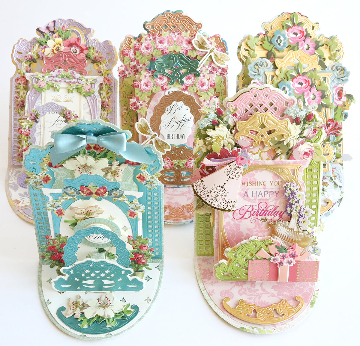 A collection of ornate, floral-themed birthday cards with intricate designs, featuring bows, flowers, and decorative elements in various pastel colors.