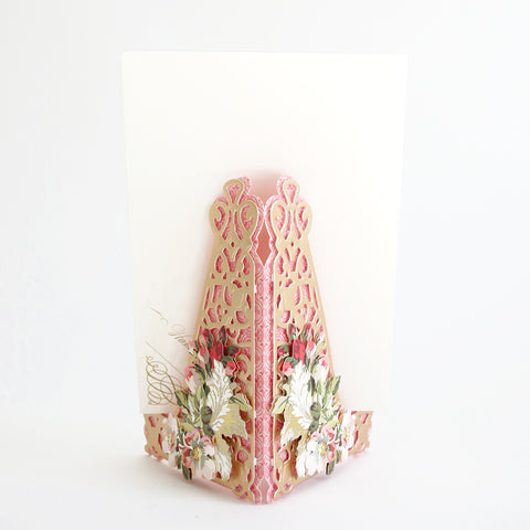 A pink and white card with flowers on it.
